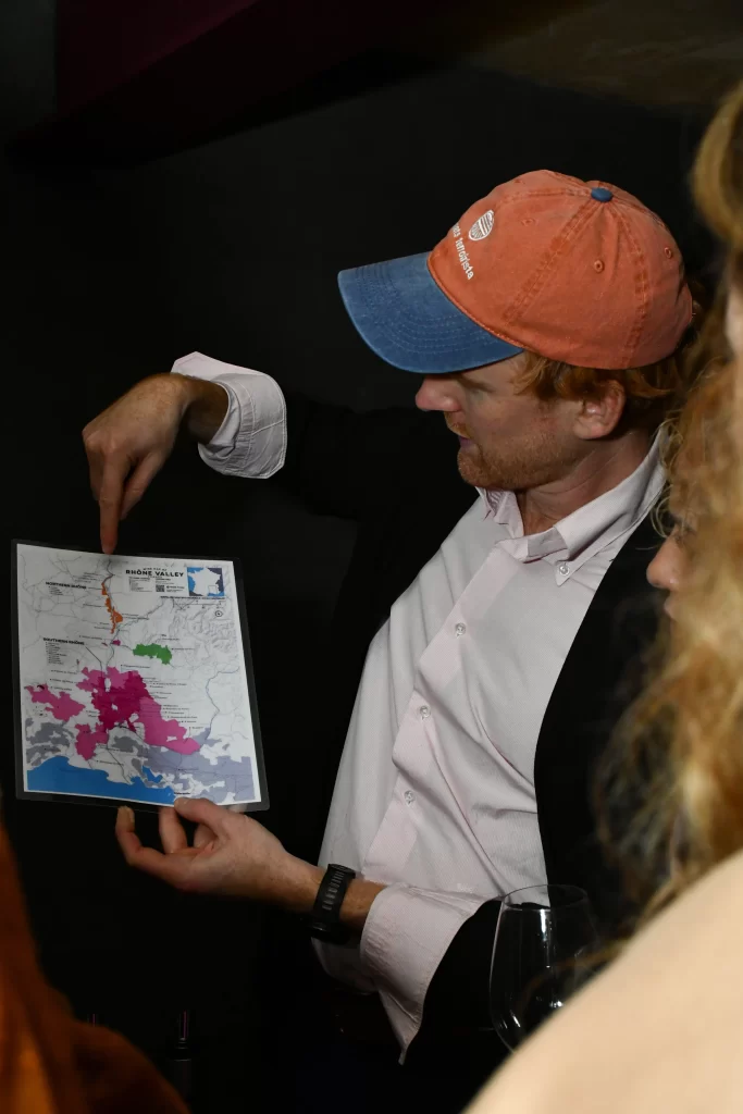 Tanguy de Bodinat, el fundador de Climats, esta enseñando una carta para explicar el tipo de suelo de las viñas a un cliente en el Festival Climats 2026.