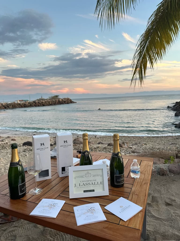 Botellas de Champagne J Lassalle en la playa de Punta Mita, con una vista al océano
