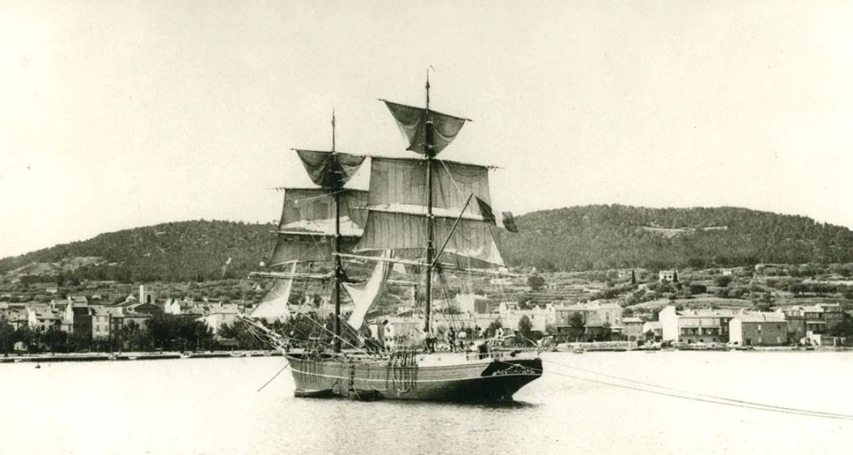 Barco de vela en puerto tranquilo.
